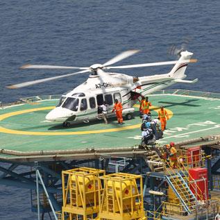 Passengers boarding offshore helicopter on oil rig